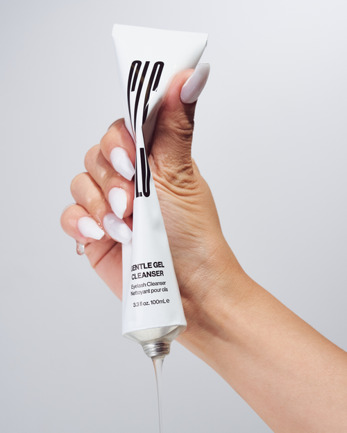 A model's hand squeezing a tube of Gentle Gel Cleanser.