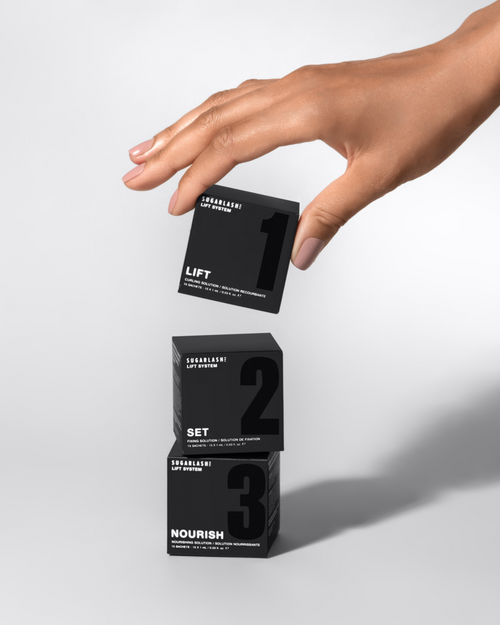 Model stacking professional Lash Lift, Set and Nourish product boxes.