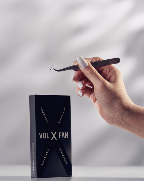 Model holding tweezers above a tray of VOL-X Loose Pre-made Fans