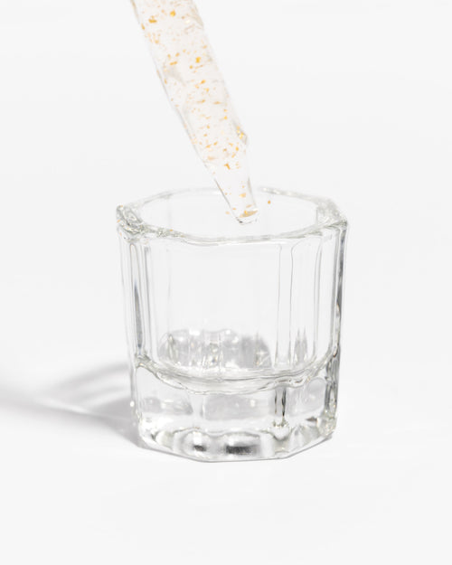 Plump product dropper above a Dappen Dish for lash Extensions.