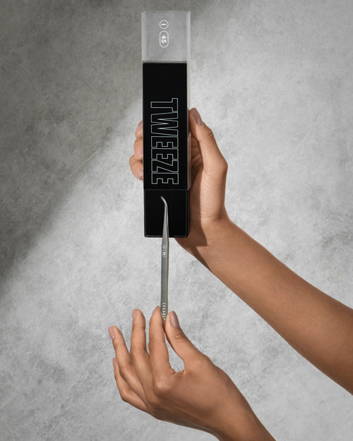 A model pulling an I-45 Isolation Tweezer out of its box. A Tool for eyelash extensions.