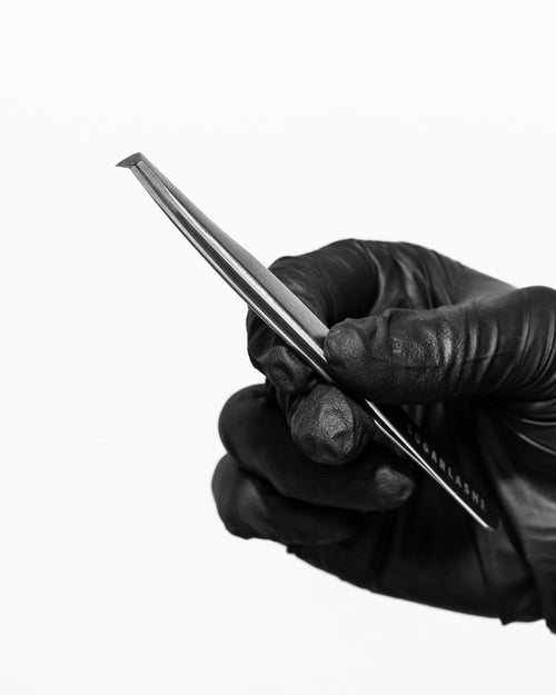 A gloved model holding a pair of lash artist Volume eyelash extensions Tweezer V-65.