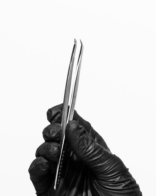 A Volume Tweezer V-PRO in a black gloved hand for eyelash extensions.