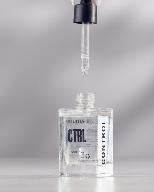 A model holding the dropper applicator above the Control bottle.