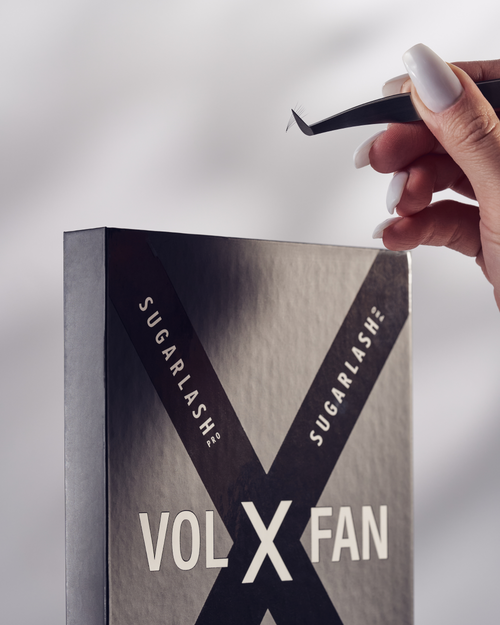 A model holding tweezers above a tray of VOL-X pre-made fans.