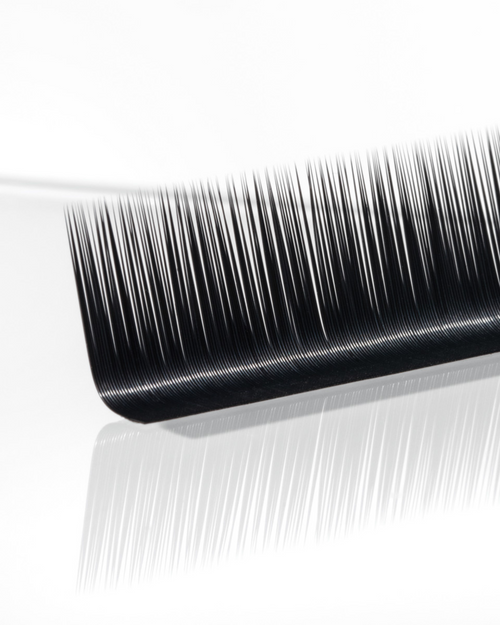 A strip of Flat lashes for eyelash extensions on a white surface.