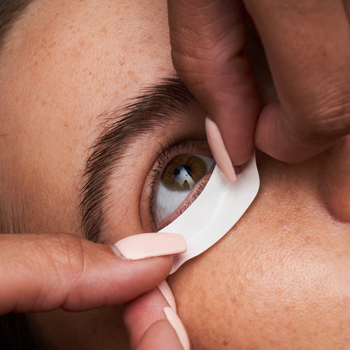 A lash artist applying a Gel Free Eye Pad to a client's under eye.