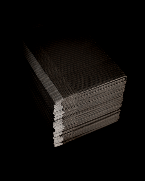 Stack of black Lash Artist Workplace Covers on a darker black background.